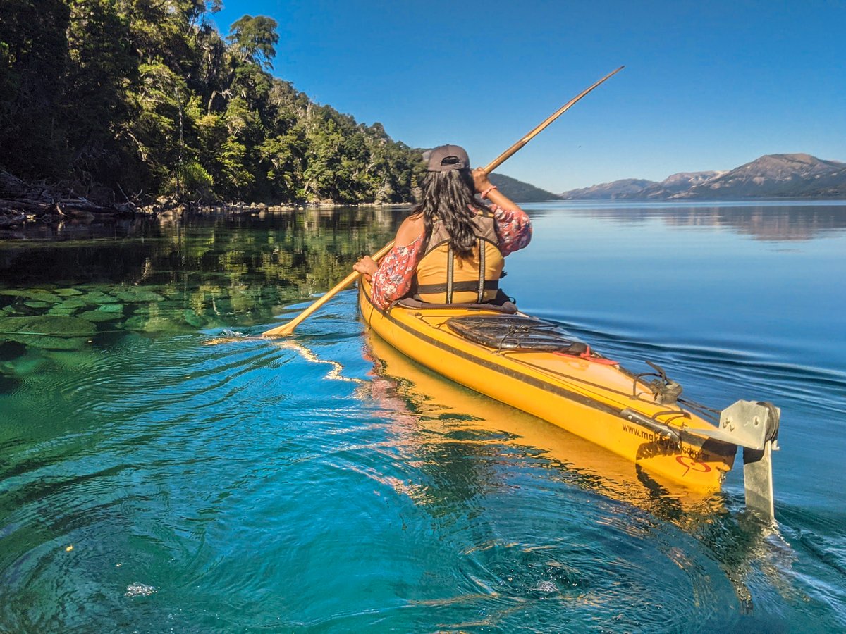 A kayak paddle blade dipping into the water