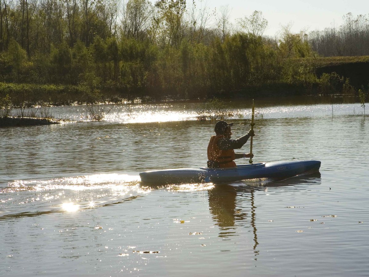 A paddler wearing a life jacket on calm water