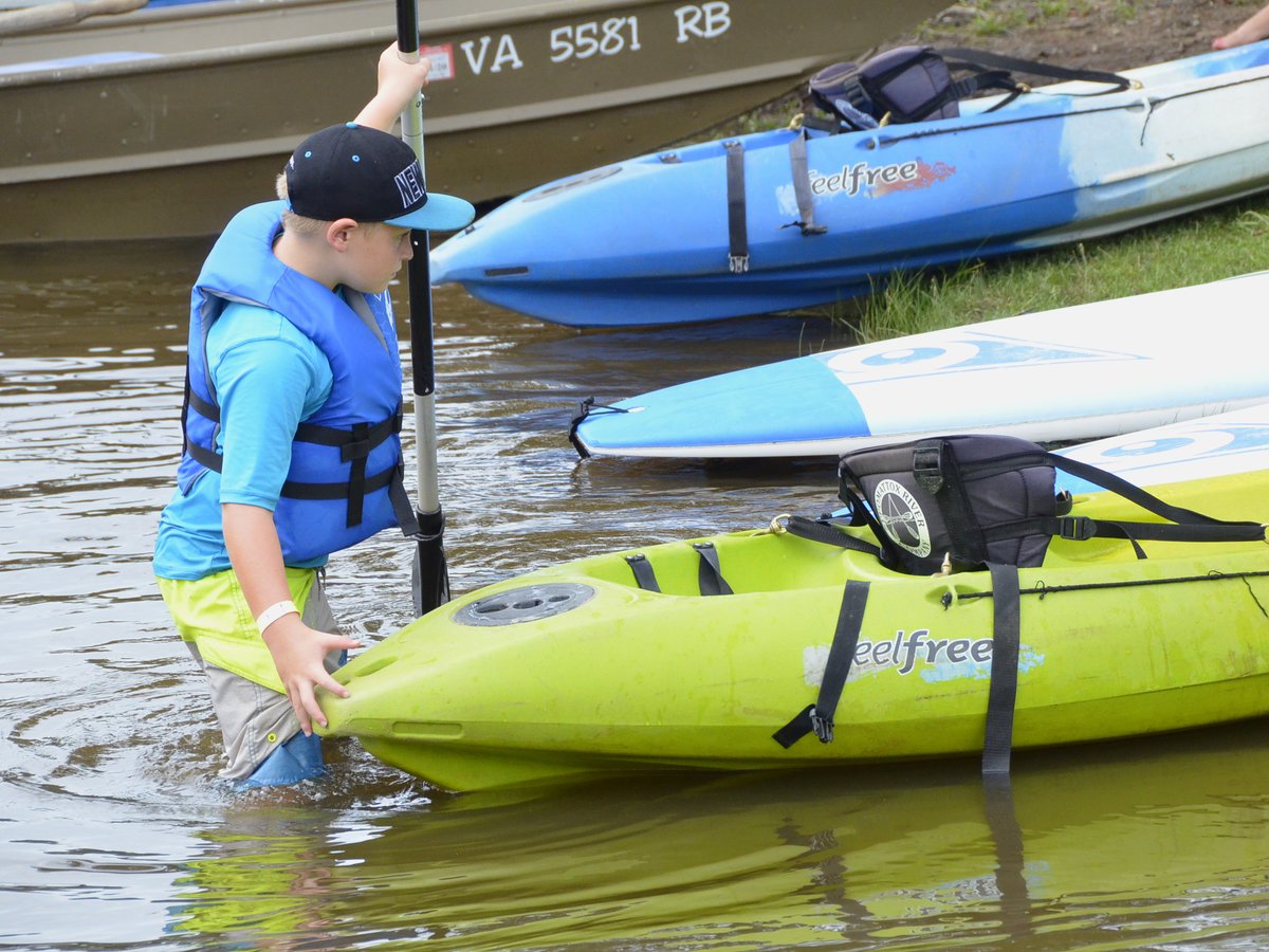 A kayak paddle and a life jacket on a dock